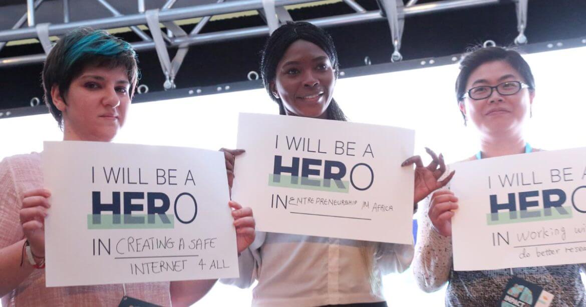 Graduate students holding HERoes signs