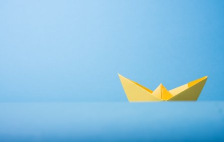 A paper boat on paper water, symbolizing whether or not programs like the AICPA Dynamic Audit Solution will hold water.