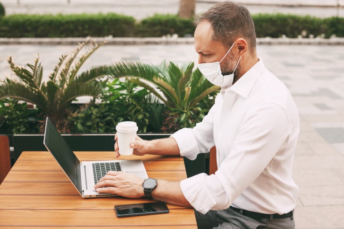 A professor working on their accounting curriculum remotely from an outdoor cafe.